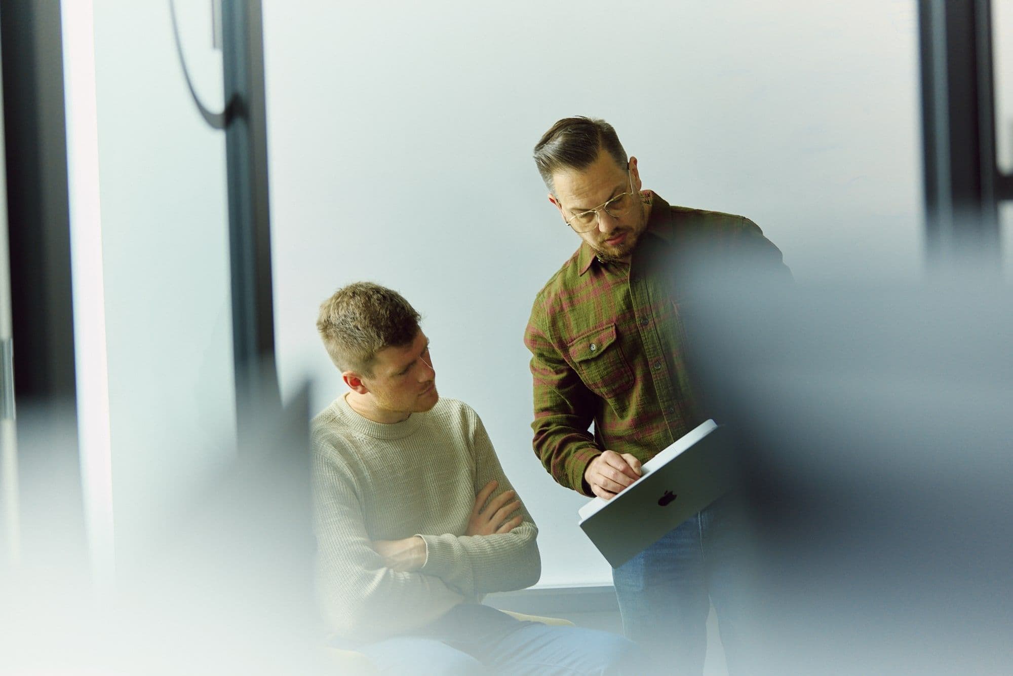 A smiling team member in conversation, pencil in hand